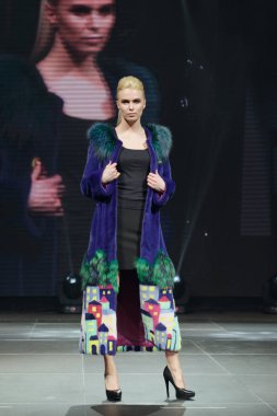 Arka plan üzerinde online ekran ile güzel manken kürk manto pist yürür