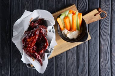 Aperatif bira için. Baharatlı tavuk kanadı taze havuç ve kereviz ve sos ile