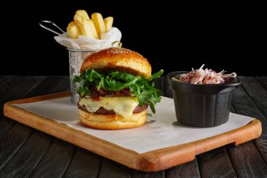 Kızarmış patates ve kırmızı lahana ile sulu biftek burger İsveç kirazı sosu, eritilmiş peynir, roka ile servis