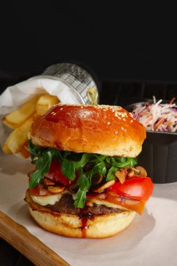 Kızarmış patates ve kırmızı lahana ile sulu biftek burger İsveç kirazı sosu, eritilmiş peynir, roka ile servis