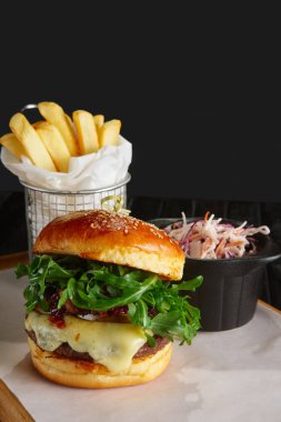 Kızarmış patates ve kırmızı lahana ile sulu biftek burger İsveç kirazı sosu, eritilmiş peynir, roka ile servis