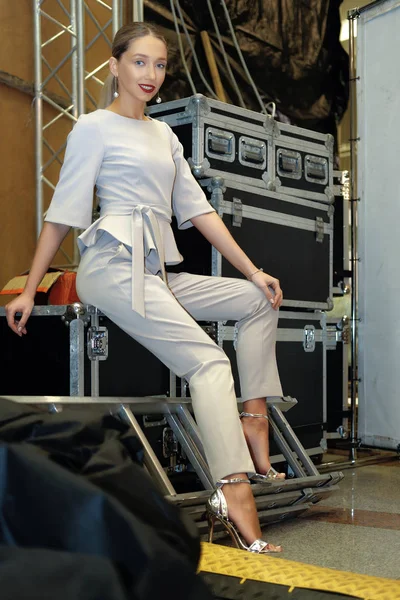 Modelo de moda bastante sentado entre los casos de equipo en el backstage — Foto de Stock