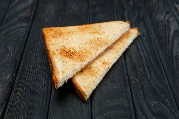 Zwei Scheiben Toast Brot auf dunklen Holztisch. Ansicht von oben. — Stockfoto