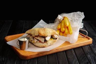 Pide et, sebze ve kızarmış patates metal sepet ve sos ile