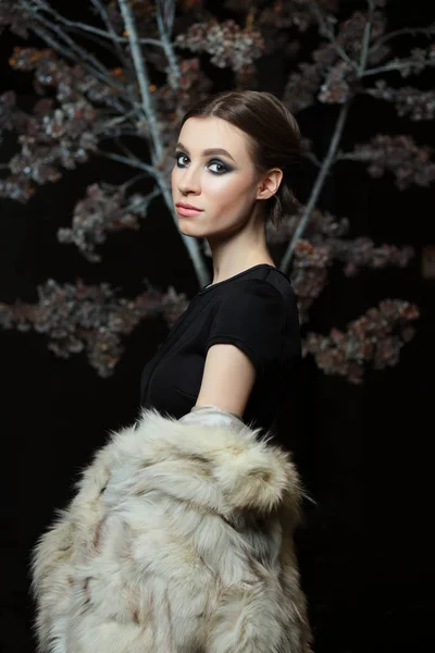 Attraente ragazza in sera make up e pelliccia abbassata su sfondo scuro — Foto Stock