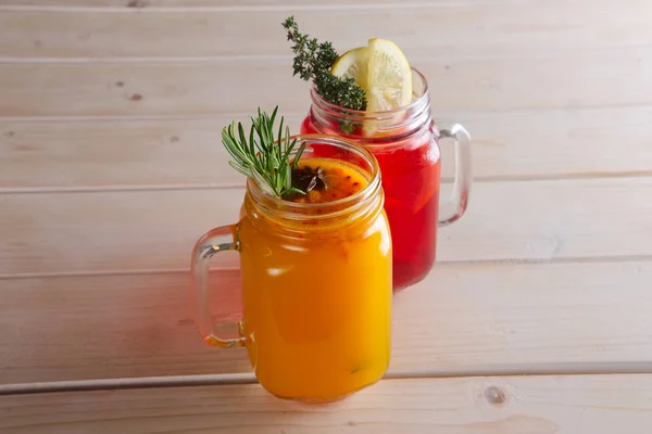 Two cups of cranberry tea and sea buckthorn tea with citrus, cinnamon and rosemary — Stock Photo, Image