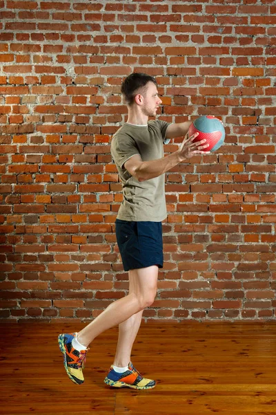 Atletisk man gör balans övningar med boll — Stockfoto