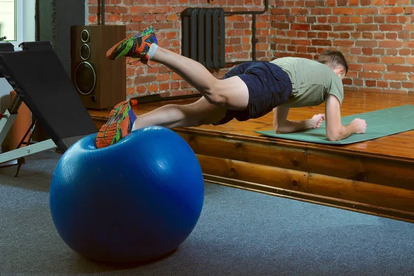 Atletisk man gör balanserande övningar med gym bollen — Stockfoto