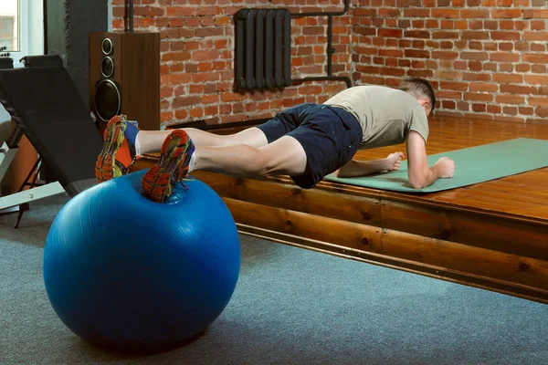 Atletisk man gör balanserande övningar med gym bollen — Stockfoto