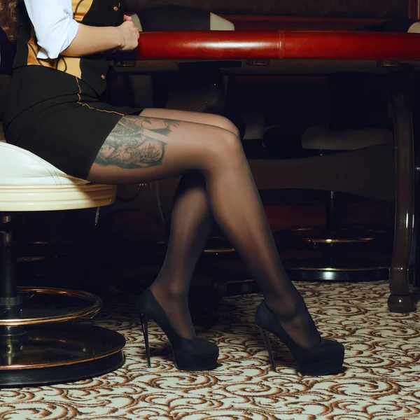 Gambe sexy del croupier del casinò in poltrona — Foto Stock