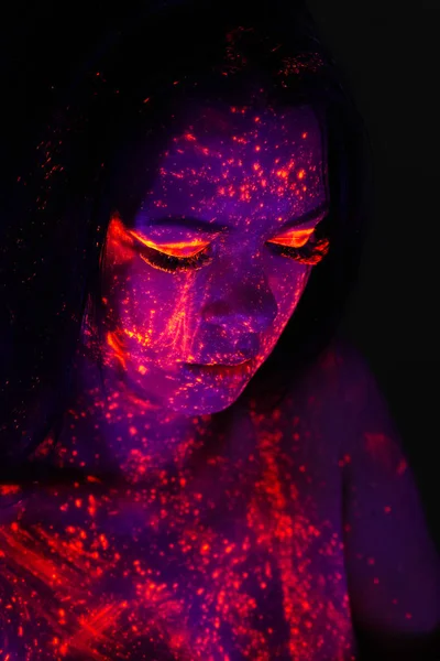 Close-up portrait of beautiful girl with ultraviolet paint on he