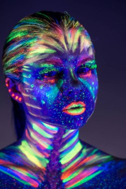 Yüzünde ultraviyole boya ile güzel kız portresi. G