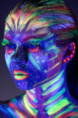 Yüzünde ultraviyole boya ile güzel kız portresi. G