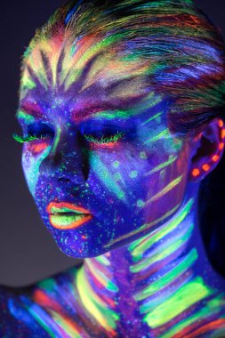 Yüzünde ultraviyole boya ile güzel kız portresi. G