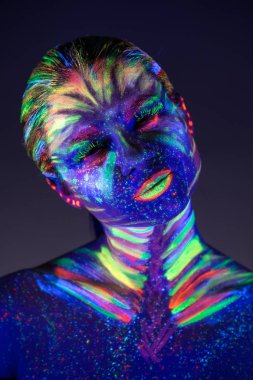 Yüzünde ultraviyole boya ile güzel kız portresi. G