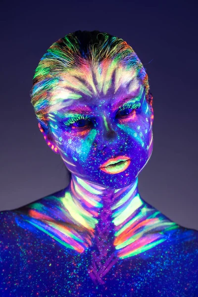 Portrait of beautiful girl with ultraviolet paint on her face. G