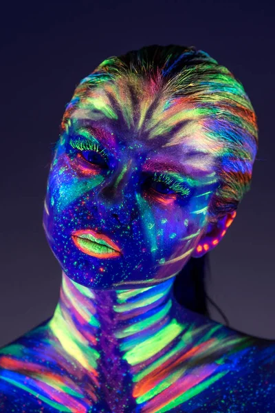 Portrait of beautiful girl with ultraviolet paint on her face. G