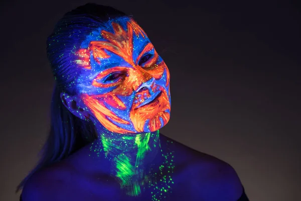 Retrato de una hermosa chica con pintura ultravioleta en su cara. G —  Fotos de Stock