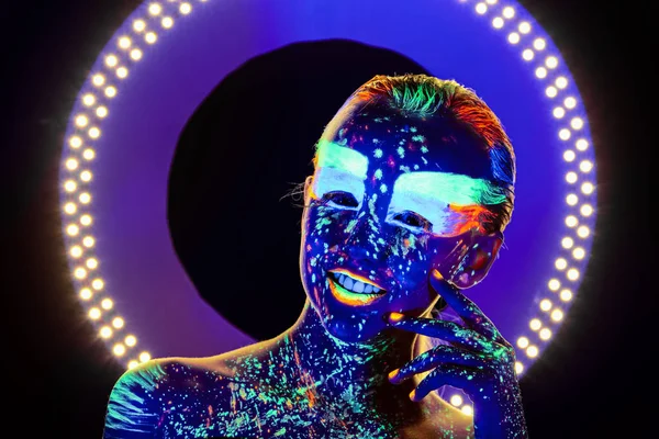 Portrait of beautiful girl with ultraviolet paint on her face. Girl with neon make-up in color light. — Stock Photo, Image