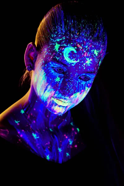 Retrato de una hermosa chica con pintura ultravioleta en su cara. Chica con maquillaje de neón en luz de color . —  Fotos de Stock