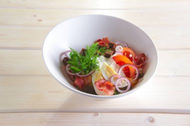 Kızarmış patates, pastırma, kahverengi ekmek cips, yumurta, domates ve soğan ile ülke salatası