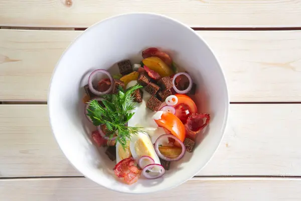 Деревенский салат с жареным картофелем, беконом, коричневыми хлебными чипсами, яйцом, помидорами и луком — стоковое фото