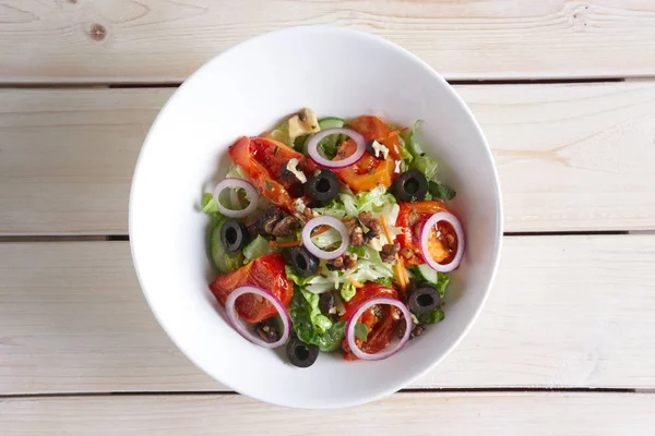 Салат с жареными помидорами, грецкими орехами, огурцом, луком и оливками — стоковое фото