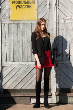 Çekici kız uyarı plakalı fabrika kapı önünde poz