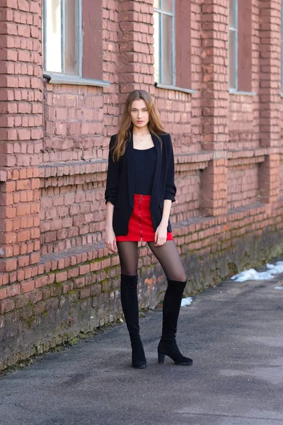 Street fashion, urban style. Girl in jacket, t-shirt, short skirt and high boots — Stock Photo, Image