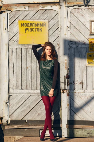 Modemodel posiert in Fabriktür mit Warnschild. — Stockfoto