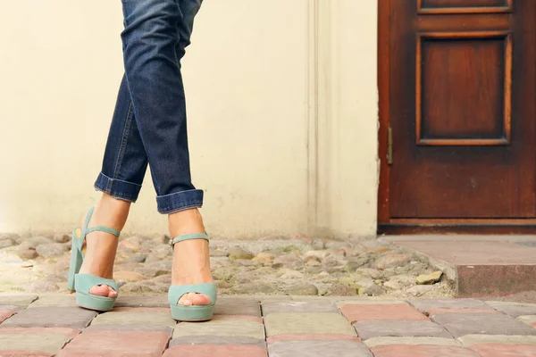 Pernas femininas finas em jeans e sapatos de conforto ao ar livre — Fotografia de Stock