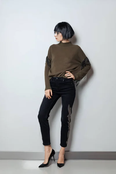 Modelo de moda en peluca negra, jersey con flecos y jeans con pedrería — Foto de Stock