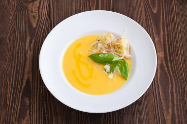 Mavi peynirli peynir çorbası ve koyu ahşap arka planda kızarmış ekmek.