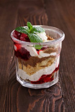 Koyu ahşap arka planda kirazlı nefis tiramisu tatlısı.