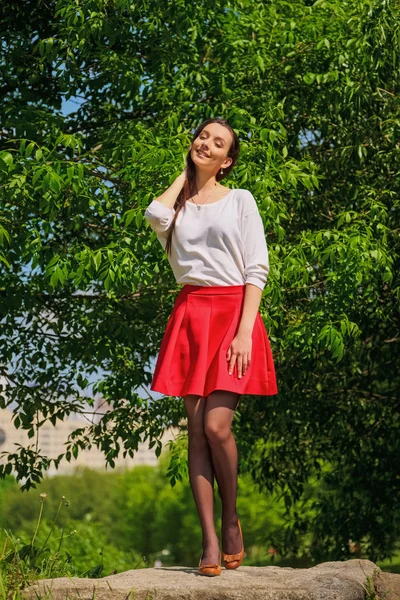 Πορτρέτο ενός κοριτσιού με κόκκινη φούστα και λευκή μπλούζα που στέκεται στην όχθη του ποταμού — Φωτογραφία Αρχείου