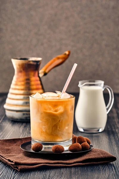 Холодный кофе со сливками на темном деревянном фоне — стоковое фото