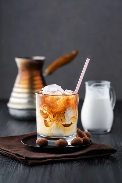 Iced coffee with cream on dark wooden table — Stock Photo, Image