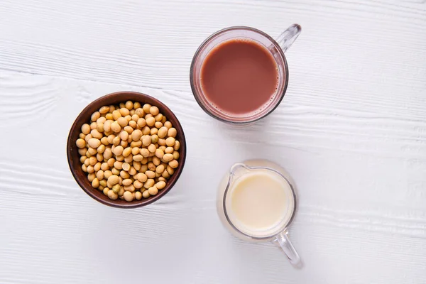 Vue du dessus du lait au chocolat et du lait de soja en verre sur table blanche — Photo