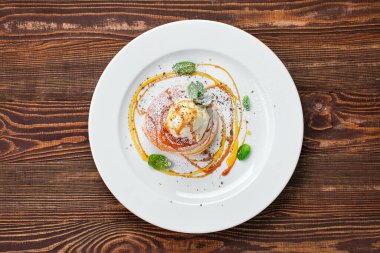 Pancakes with ice cream, whipped cream and maple syrup 