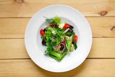 Soğan, pancar kökü, domates, feta ve soslu salata manzarası.