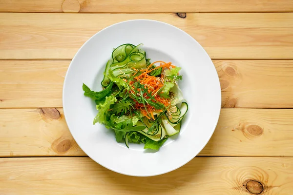 Вид сверху на салат с огурцом, пряной морковью, аругулой и — стоковое фото