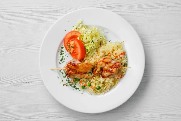Вид сверху на тарелку с куриным шашлыком, рис с горохом и салатом из капусты — стоковое фото