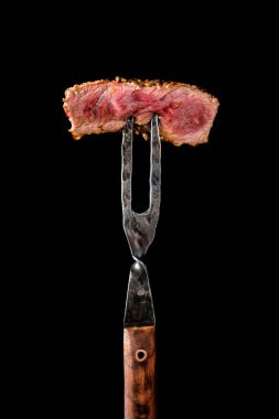 Piece of medium rare steak on the fork