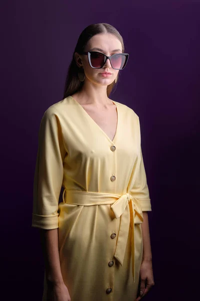 ボタンと黄色のドレスを身に着けている大きなサングラスでファッションモデルの低キーポートレート — ストック写真