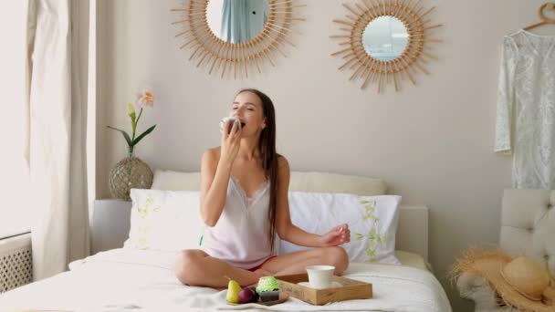 Hermosa Chica Mordiendo Pastel Mientras Desayuna Cama — Vídeo de stock