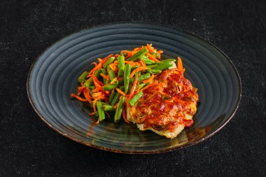 Yeşil fasulye ve baharatlı havuçla servis edilen peynirli kızarmış balık filetosu.