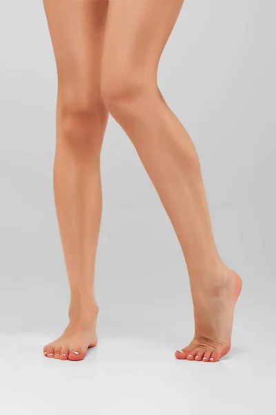 Bare muscular female legs on tiptoe