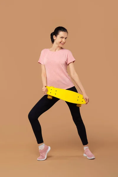 Sportliches Mädchen Mit Skateboard Vor Beigem Hintergrund — Stockfoto