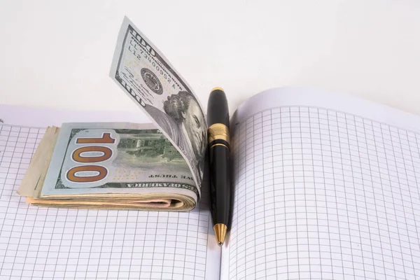 Dólares y vasos, bolígrafo, cuaderno —  Fotos de Stock
