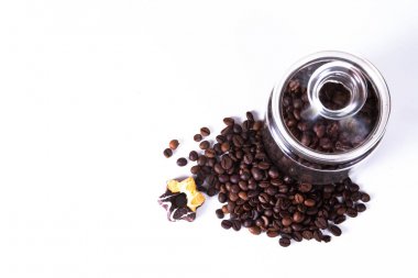 Eski mutfak masasında bir kavanoza kahve çekirdekleri.